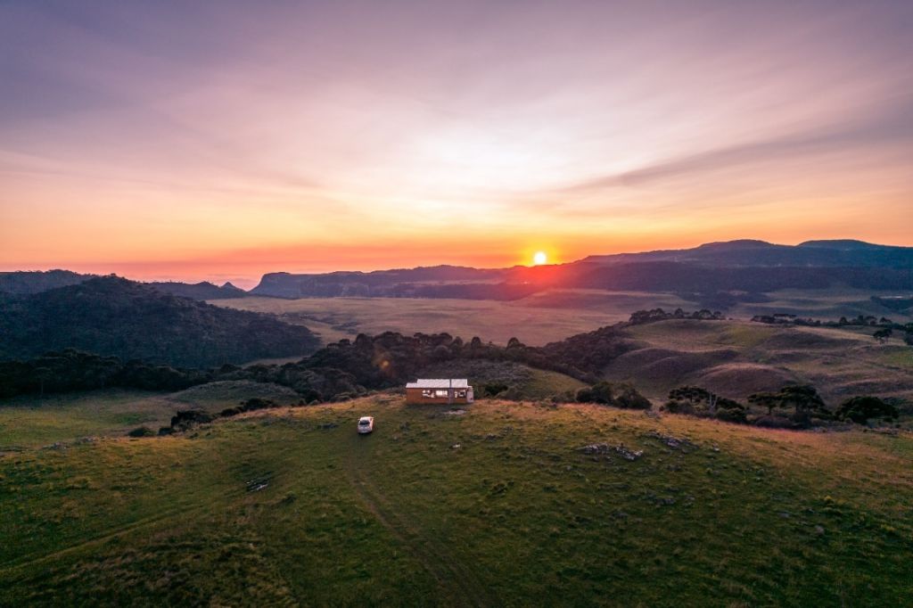 Cabana na colina ao pôr do sol